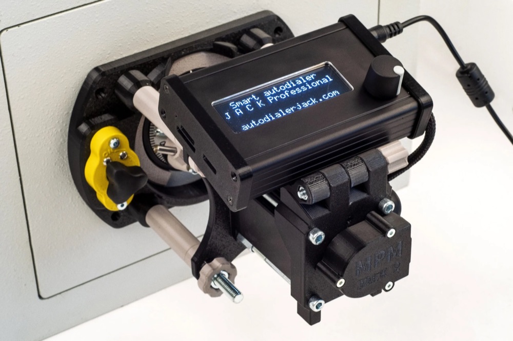 JACK Professional autodialer mounted on a safe dial, with its display reading Smart autodialer JACK Professional