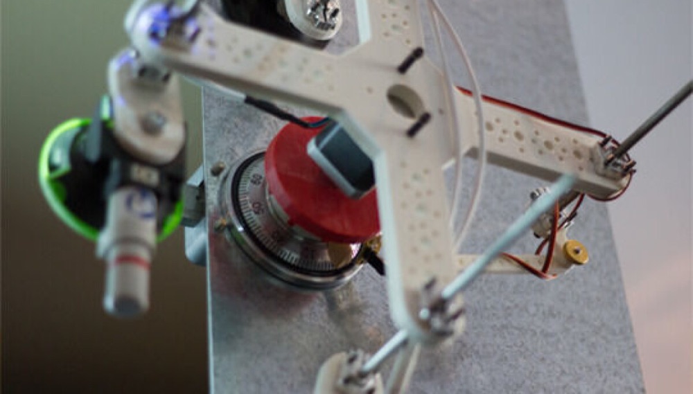 Ruxcon 2014 autodialer: 3D-printed arms holding a motor and red dial coupler over a safe dial
