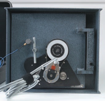 SoftDrill mounted on a safe door: black magnetic bracket, stepper motor belted to a pulley on the dial, and the magnetic transducer microphone attached above