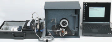 Complete SoftDrill setup: briefcase control unit, safe with the motor and microphone fitted, and a laptop running the software